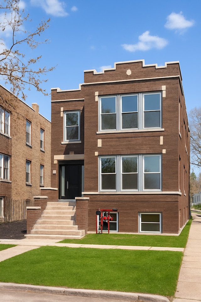 view of front of home featuring a front lawn and brick siding