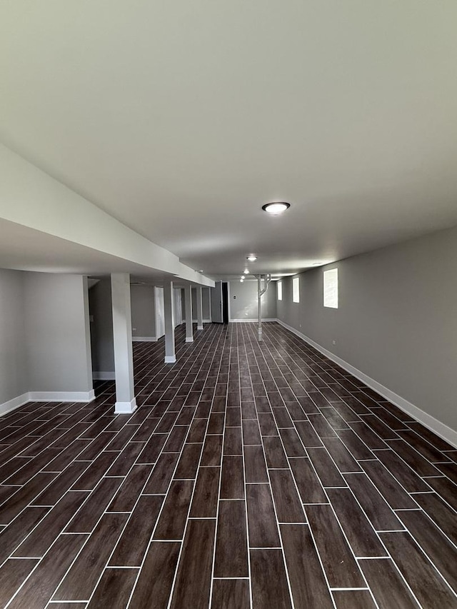 below grade area featuring baseboards and dark wood-type flooring