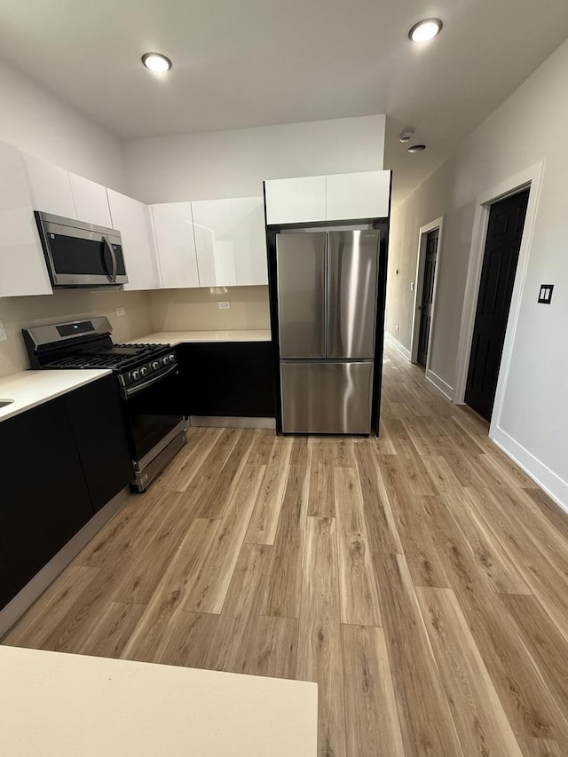 kitchen with white cabinetry, stainless steel appliances, modern cabinets, and light countertops