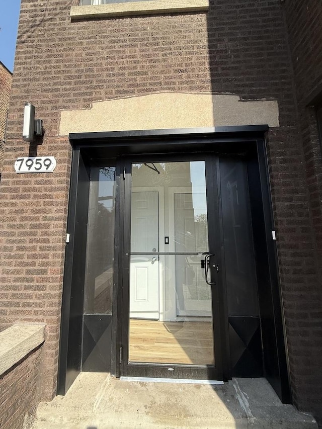 view of exterior entry featuring brick siding