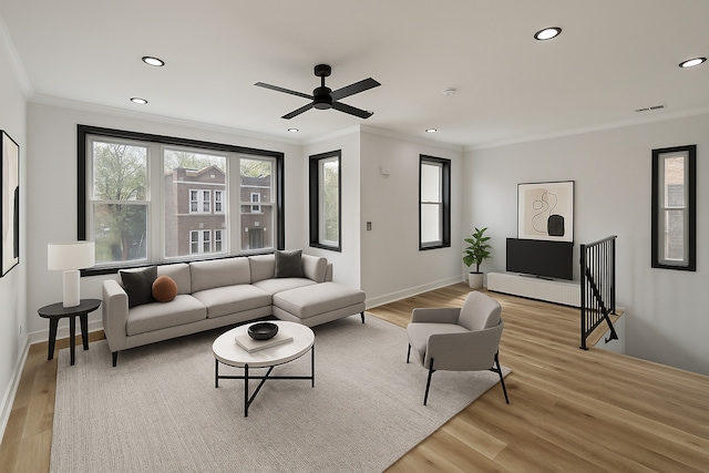 living room featuring a ceiling fan, crown molding, light wood-style flooring, and recessed lighting