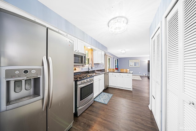 2860 Bridgeport Ln, Aurora, IL 60504 - kitchen with appliances with stainless steel finishes, a peninsula, white cabinets, a chandelier, and dark wood finished floors