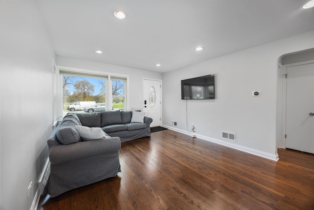 living room featuring dark wood-style flooring, baseboards, visible vents, and recessed lighting