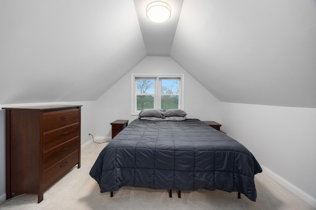bedroom featuring baseboards, vaulted ceiling, and light carpet
