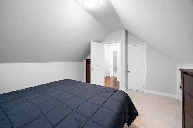 bedroom featuring carpet and vaulted ceiling
