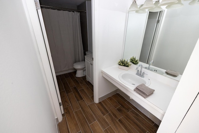 full bath with a shower with shower curtain, wood tiled floor, toilet, and vanity