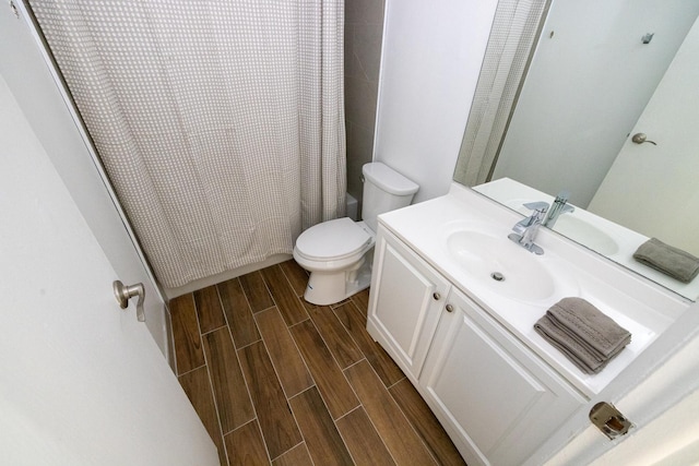 bathroom featuring toilet, vanity, wood finish floors, and shower / tub combo with curtain