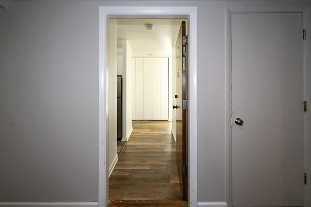 hallway with wood finished floors and baseboards