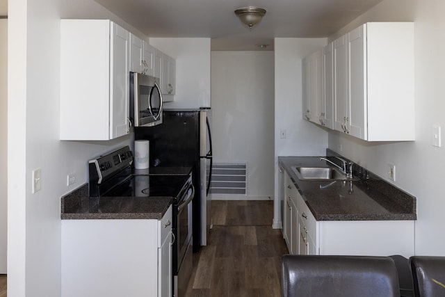 kitchen featuring white cabinetry, stainless steel appliances, dark wood finished floors, and a sink