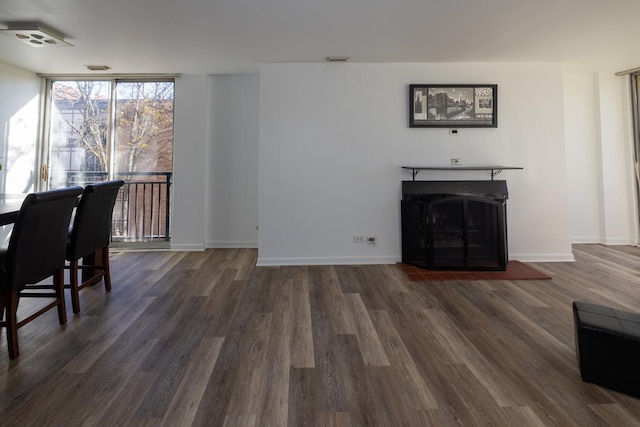 living area with dark wood-type flooring, baseboards, floor to ceiling windows, and a fireplace