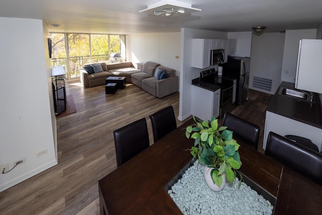 dining room featuring dark wood-style floors, ceiling fan, and baseboards