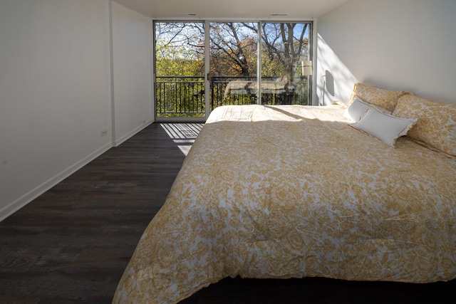 bedroom featuring baseboards, access to exterior, dark wood-style flooring, and floor to ceiling windows