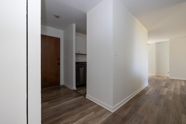 hallway with dark wood finished floors and baseboards