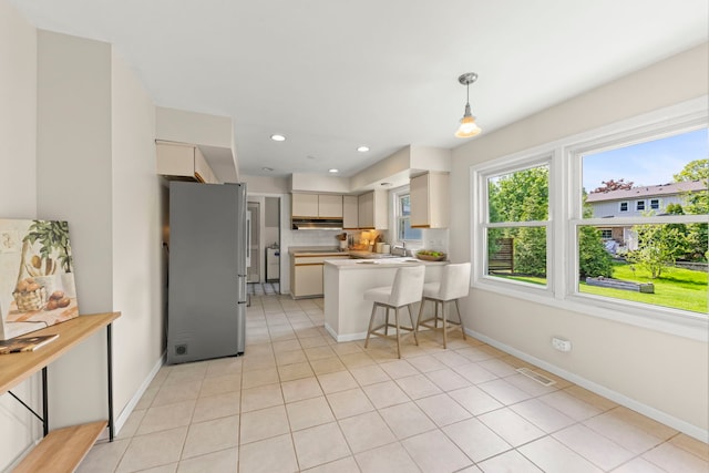 542 Stafford Ln, Glen Ellyn, IL 60137 - kitchen with freestanding refrigerator, a peninsula, light countertops, light tile patterned floors, and tasteful backsplash