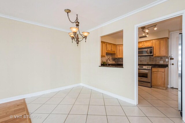 kitchen with decorative backsplash, visible vents, a sink, light tile patterned floors, and stainless steel appliances