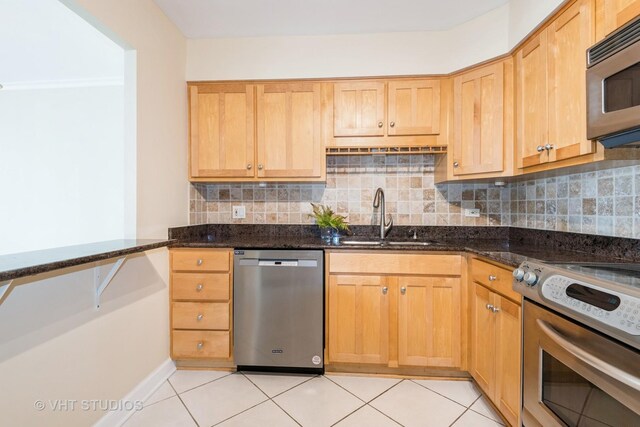 kitchen with a kitchen breakfast bar, visible vents, light brown cabinetry, a center island with sink, and stainless steel appliances