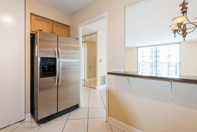 unfurnished dining area featuring ornamental molding, a sink, light tile patterned floors, and a notable chandelier