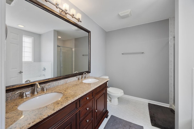 bathroom featuring double vanity, a sink, a stall shower, and toilet