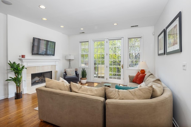 living area featuring dark wood-type flooring, recessed lighting, a wealth of natural light, and a fireplace