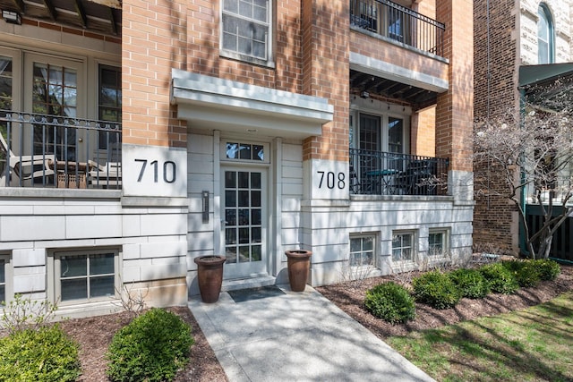 view of exterior entry featuring brick siding