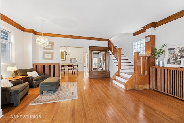 309 Wesley Ave, Oak Park, IL 60302 - living room with stairway, ornamental molding, a notable chandelier, and light wood-style floors