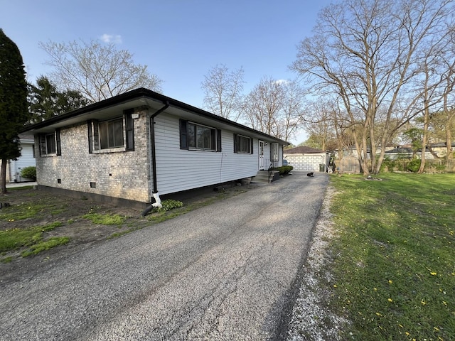 view of front facade featuring crawl space, an outbuilding, a garage, brick siding, and entry steps