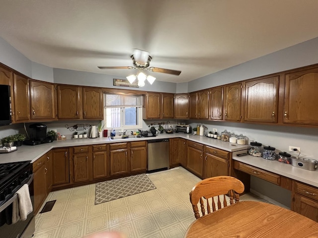 kitchen featuring ceiling fan, a sink, light countertops, stainless steel dishwasher, and gas range oven