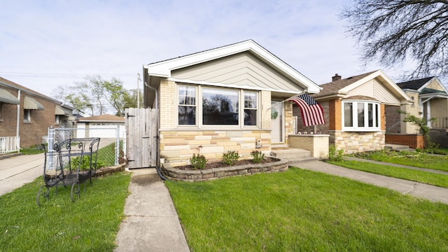 bungalow-style house with fence, a gate, a front yard, and brick siding