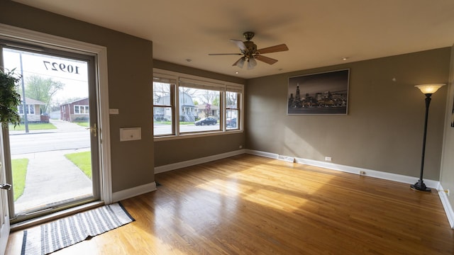 entrance foyer with wood finished floors, a ceiling fan, visible vents, and baseboards