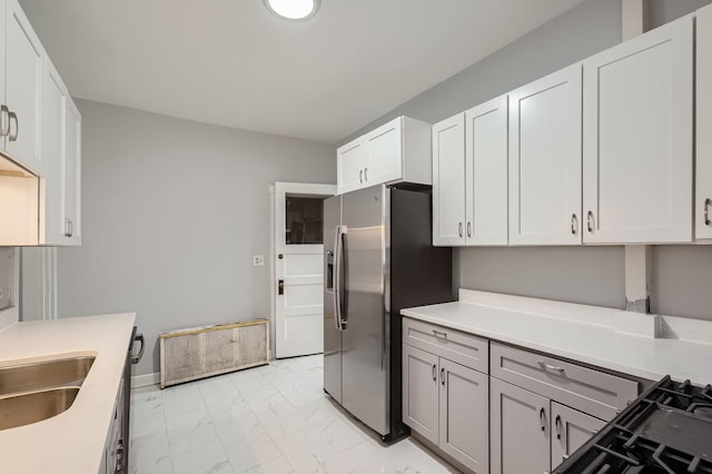 kitchen featuring a sink, marble finish floor, light countertops, white cabinets, and stainless steel fridge with ice dispenser