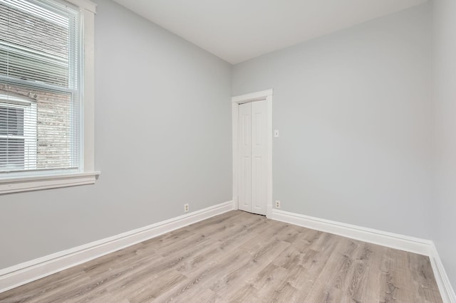 unfurnished room featuring baseboards and light wood-style flooring