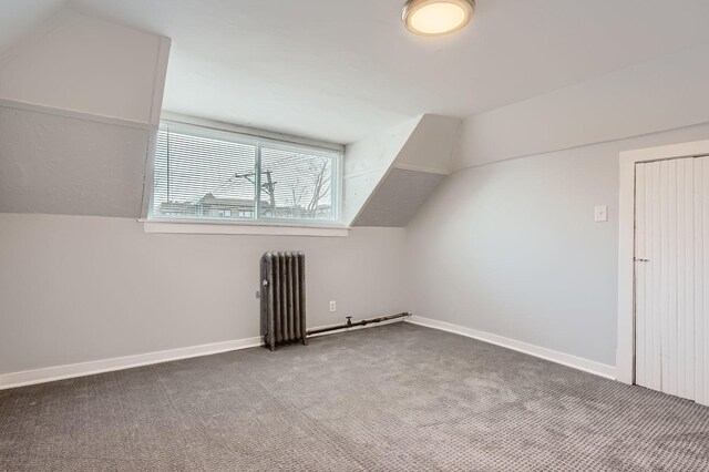 bonus room with baseboards, radiator, carpet floors, and vaulted ceiling