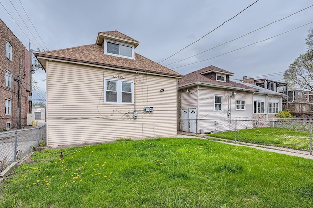 view of front of home with a front yard, a fenced backyard, and roof with shingles