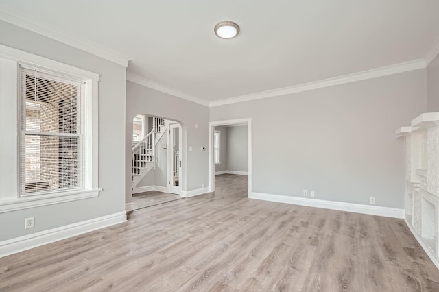 interior space with arched walkways, stairs, ornamental molding, and light wood-style flooring