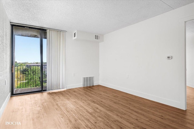 1750 N Marywood Ave Unit 501, Aurora, IL 60505 - empty room featuring a wall of windows, visible vents, wood finished floors, and baseboards