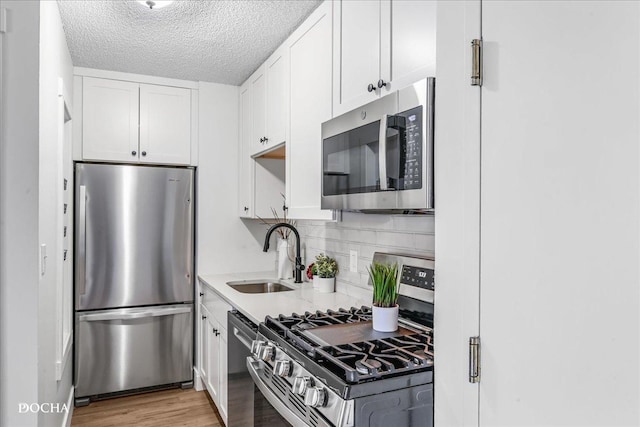 1750 N Marywood Ave Unit 501, Aurora, IL 60505 - kitchen with a sink, backsplash, light countertops, white cabinets, and appliances with stainless steel finishes