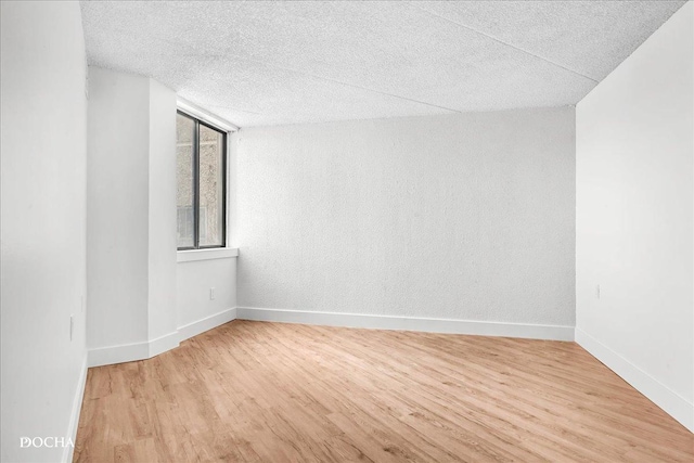 1750 N Marywood Ave Unit 501, Aurora, IL 60505 - spare room with baseboards, light wood-type flooring, and a textured ceiling