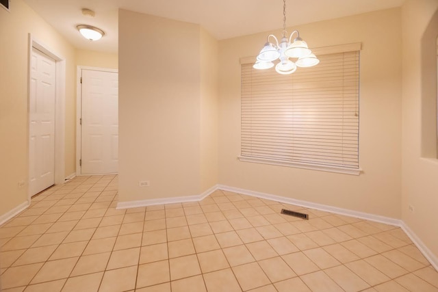 empty room featuring an inviting chandelier, baseboards, light tile patterned floors, and visible vents