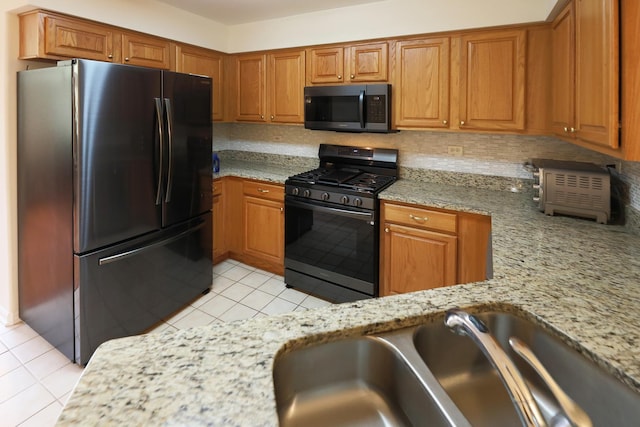 4566 Concord Ln, Northbrook, IL 60062 - kitchen with freestanding refrigerator, stainless steel gas range, light tile patterned floors, and light stone counters