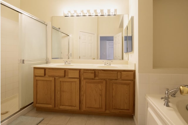 full bath with a sink, tile patterned flooring, and a stall shower