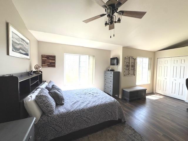 bedroom with a ceiling fan, wood finished floors, and lofted ceiling
