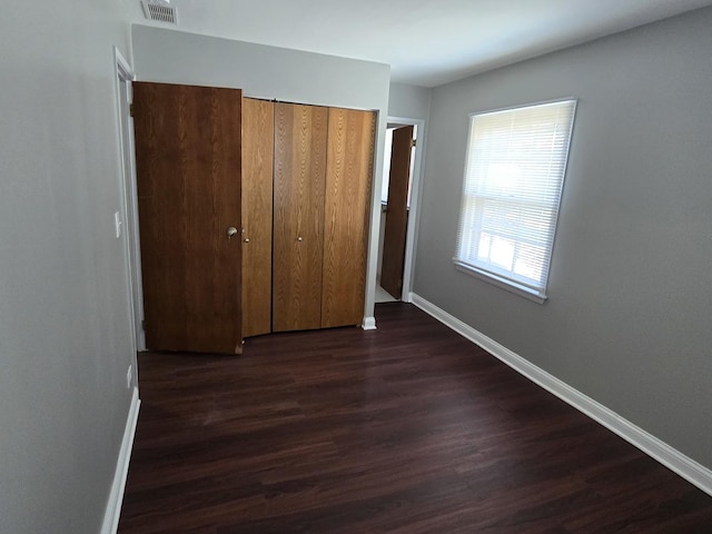 15016 S Holiday Ct, Orland Park, IL 60462 - unfurnished bedroom with baseboards, dark wood-style floors, and a closet