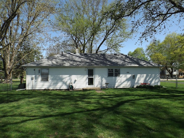 rear view of house with a yard and fence