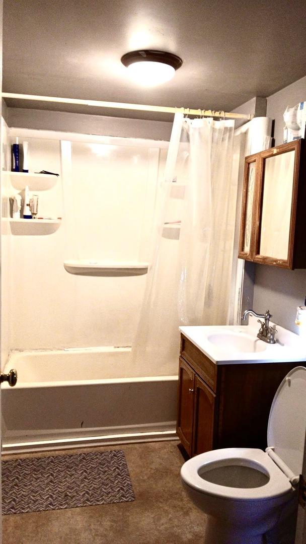 bathroom with shower / tub combo, vanity, and toilet