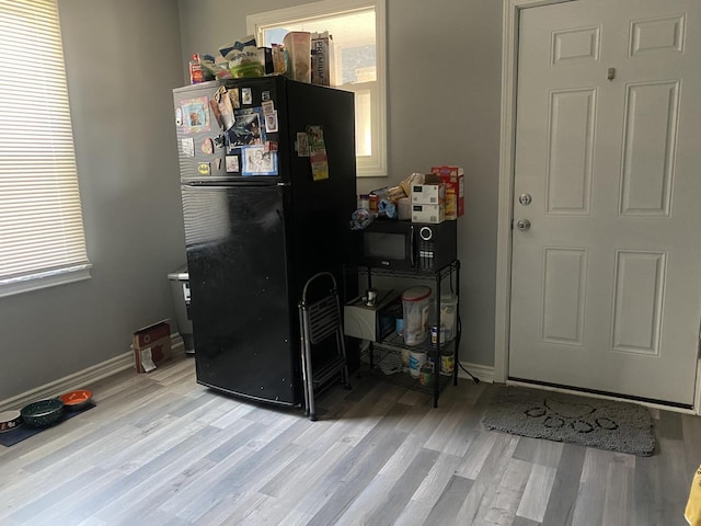 home office with baseboards and wood finished floors