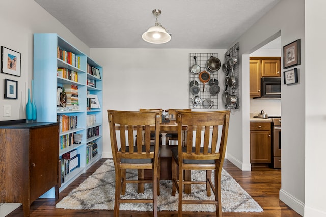 dining space with dark wood-type flooring and baseboards