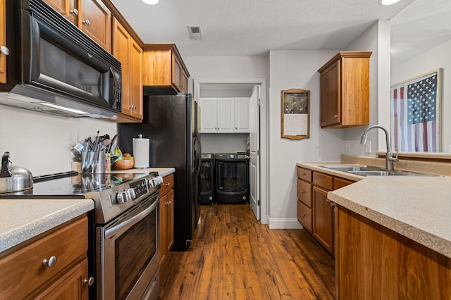 kitchen featuring brown cabinetry, black microwave, stainless steel electric range oven, washing machine and dryer, and a sink