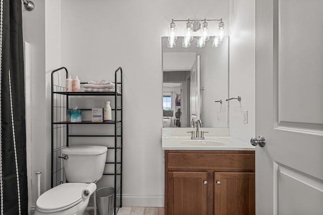 bathroom featuring toilet, a shower with curtain, baseboards, and vanity