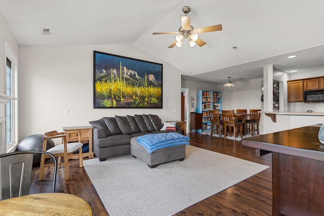 living room with visible vents, a ceiling fan, dark wood-style flooring, and lofted ceiling