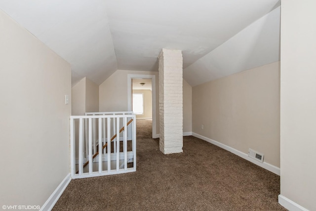 additional living space featuring baseboards, visible vents, lofted ceiling, and carpet